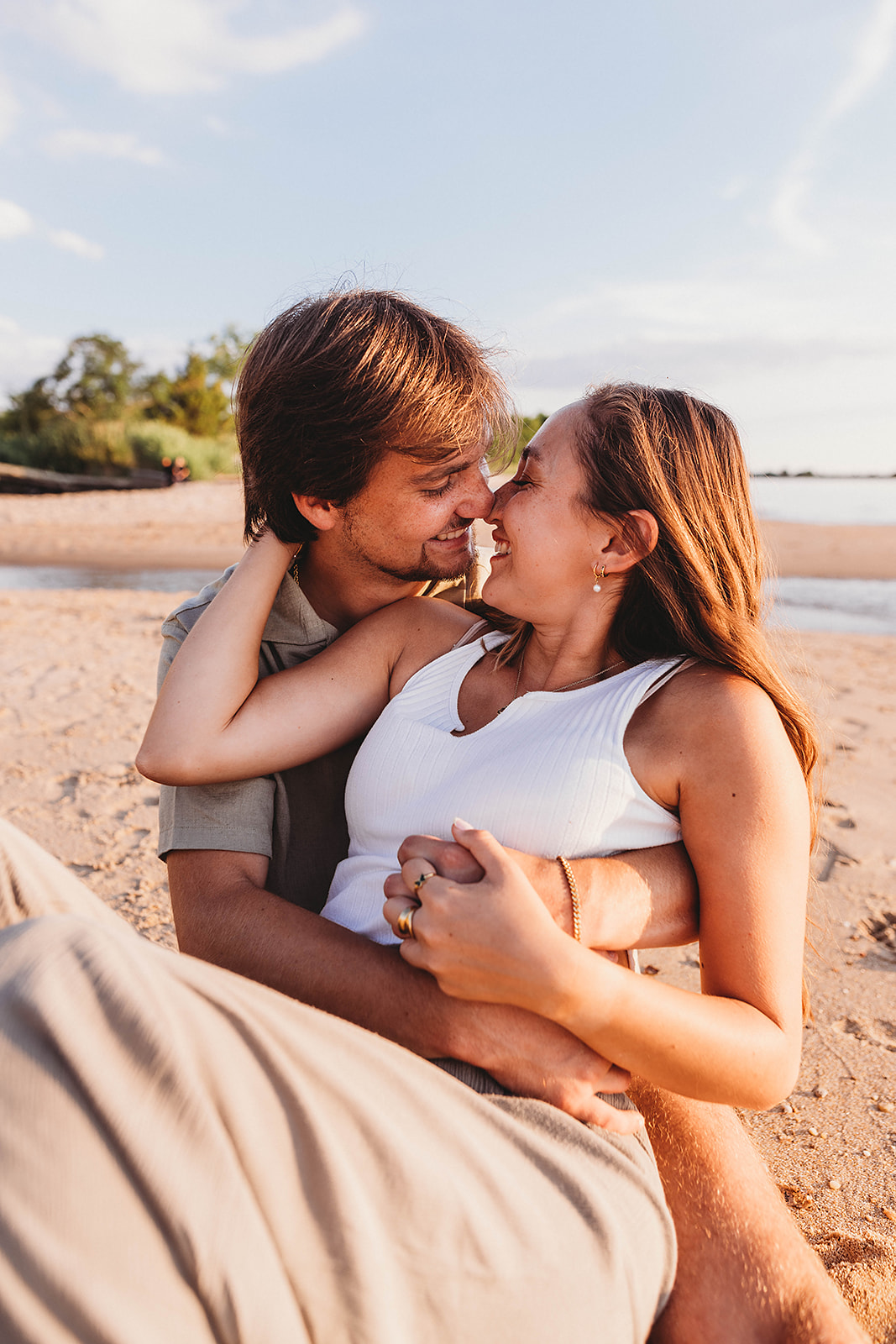 Couple snuggled up for couples photos on the beach