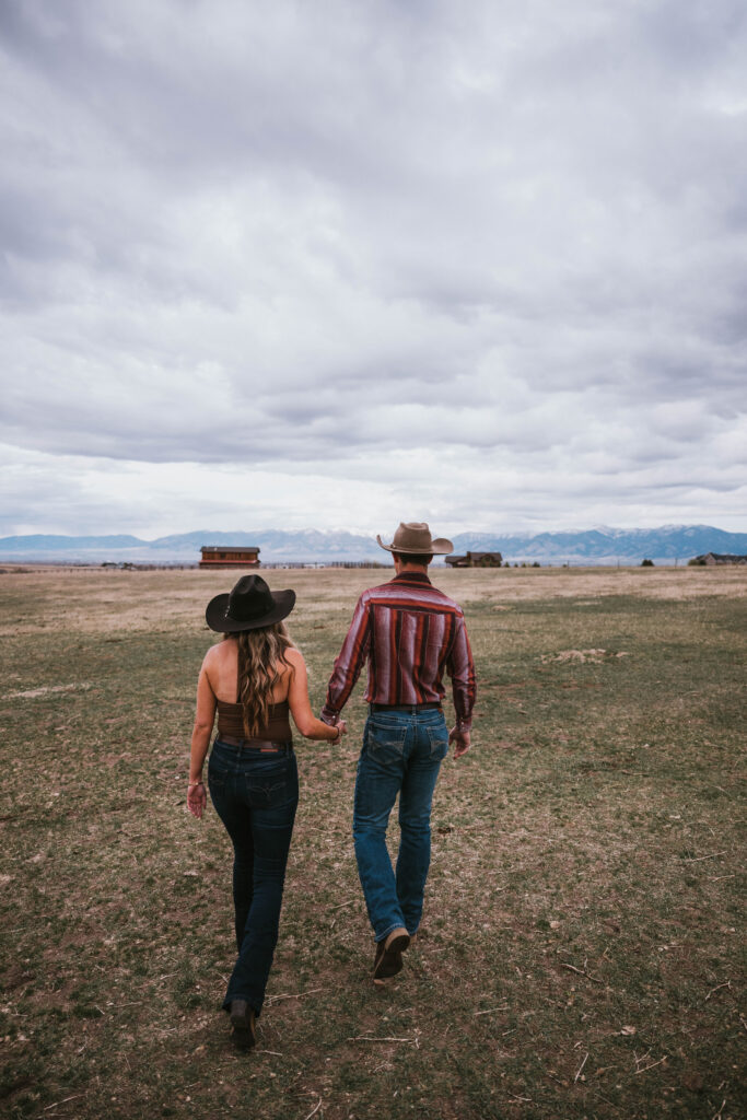 Walking toward the mountain range in Bozeman Montana for a couples photoshoot