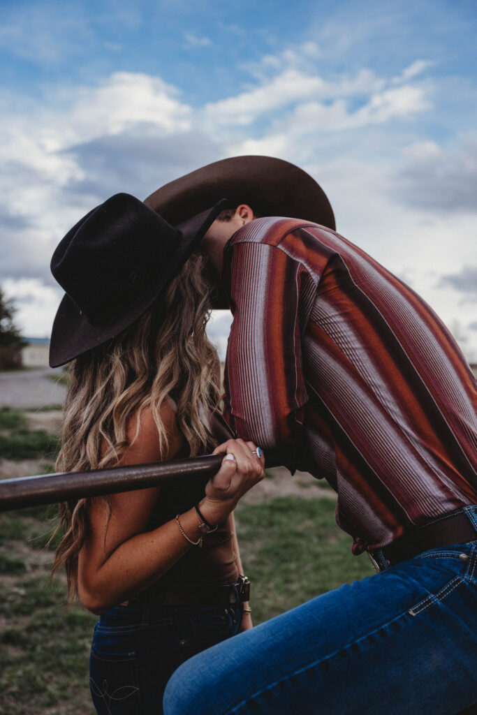 Cowboy and cowgirl sharing a sweet kiss during romantic photoshoot in Bozeman, Montana