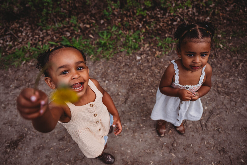 sisters picking flowers and showing the camera